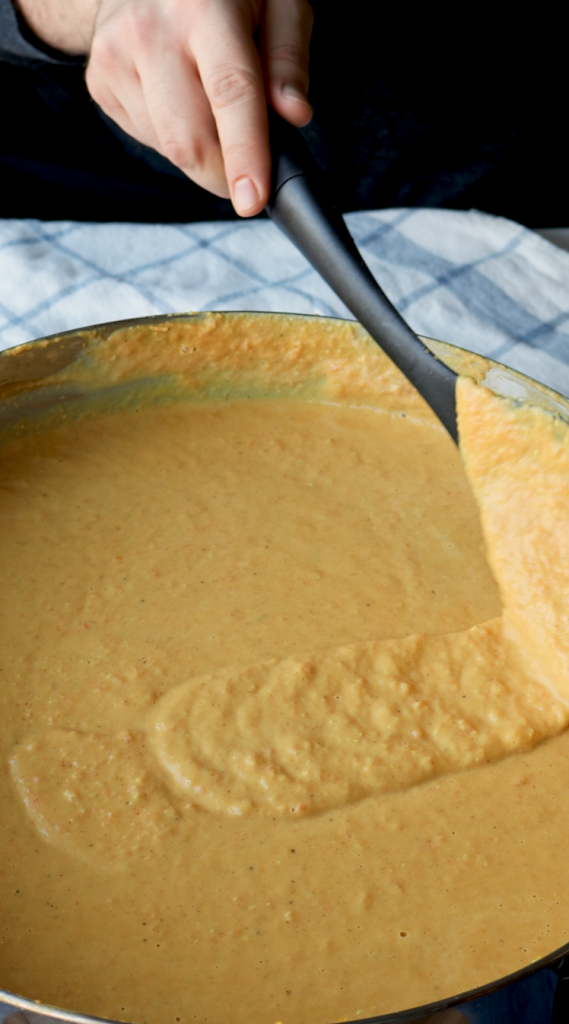 To make this creamy red lentil soup, begin by sautéing onions and minced garlic in oil. Then add carrots and seasonings. Cook for a few minutes, then add tomato paste, red lentils, and water. Bring to a boil, then cover and cook on super low for 30 minutes, or until lentils and carrots are soft. Blend until smooth, then add heavy cream. Add more heavy cream if a more soupy consistency is desired. Top with red pepper flakes and cilantro and enjoy!